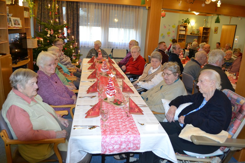 Menschen sitzen um einen gedeckten Tisch