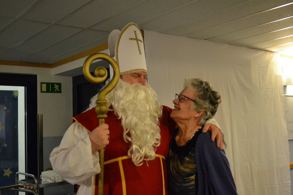 Der Nikolaus steht neben einer Heimbewohnerin