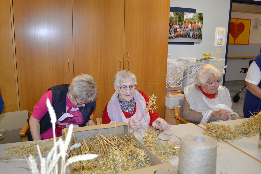 Frauen binden Erntedankkrone