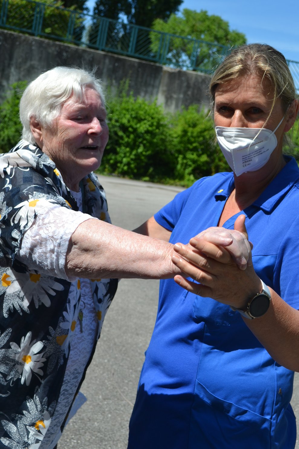 Eine Pflegerin tanzt mit einer Bewohnerin 