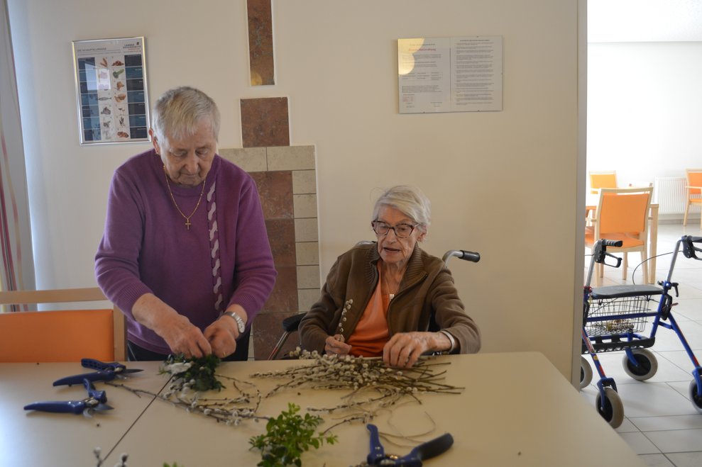 Frauen binden Palmbesen