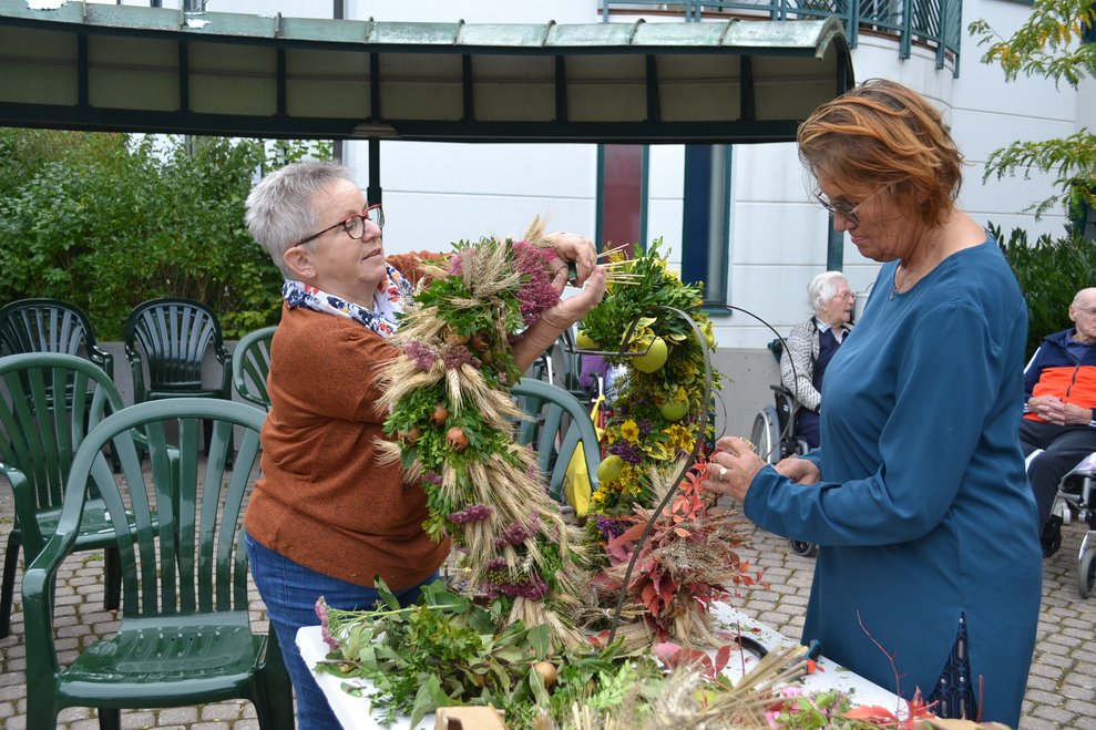 zwei Damen binden eine Erntekrone
