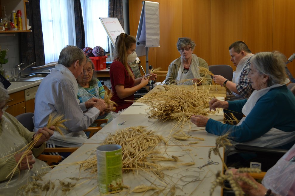 Frauen und Männer binden Getreidebündel