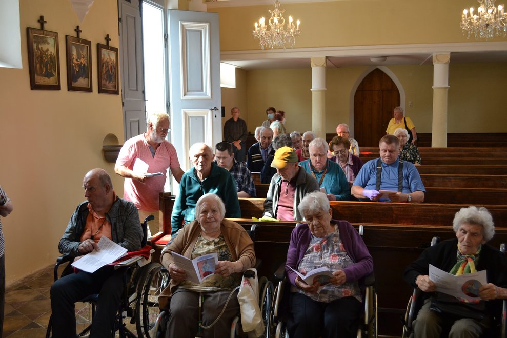mehere Bewohnerinnen und Bewohner sitzen in der Kirche