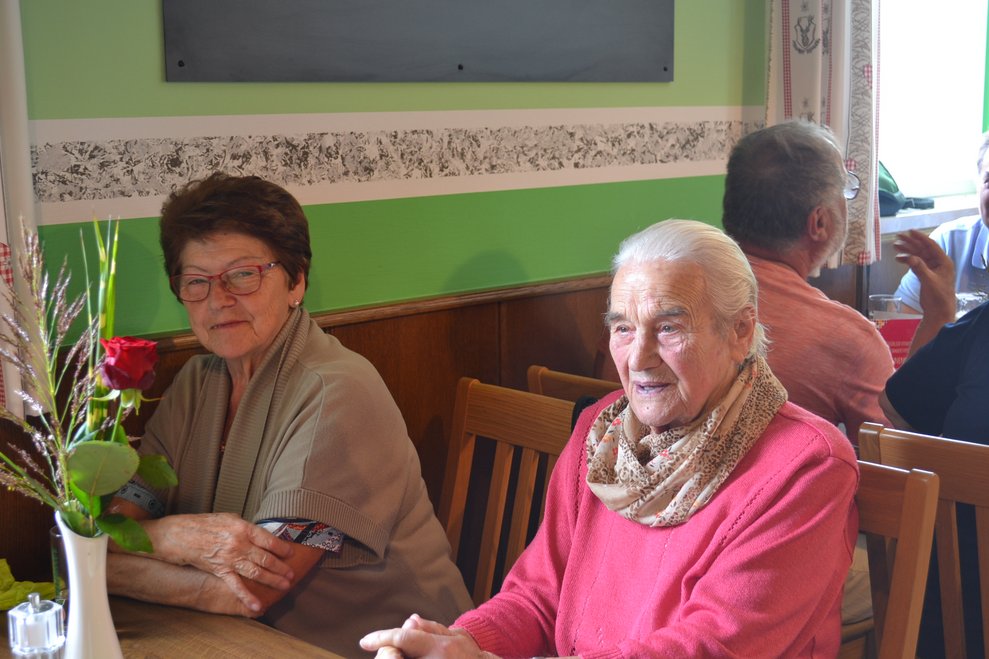 Ehrenamtliche Mitarbeiterin und Heimbewohnerin beim Tratsch im Gasthaus