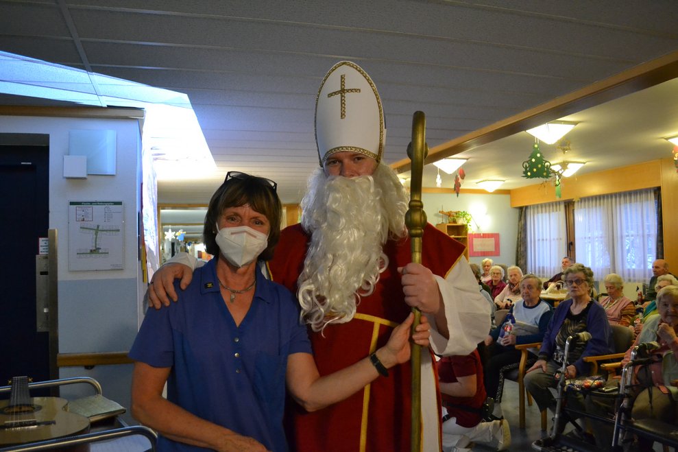 Eine Mitarbeiterin steht neben dem Nikolaus